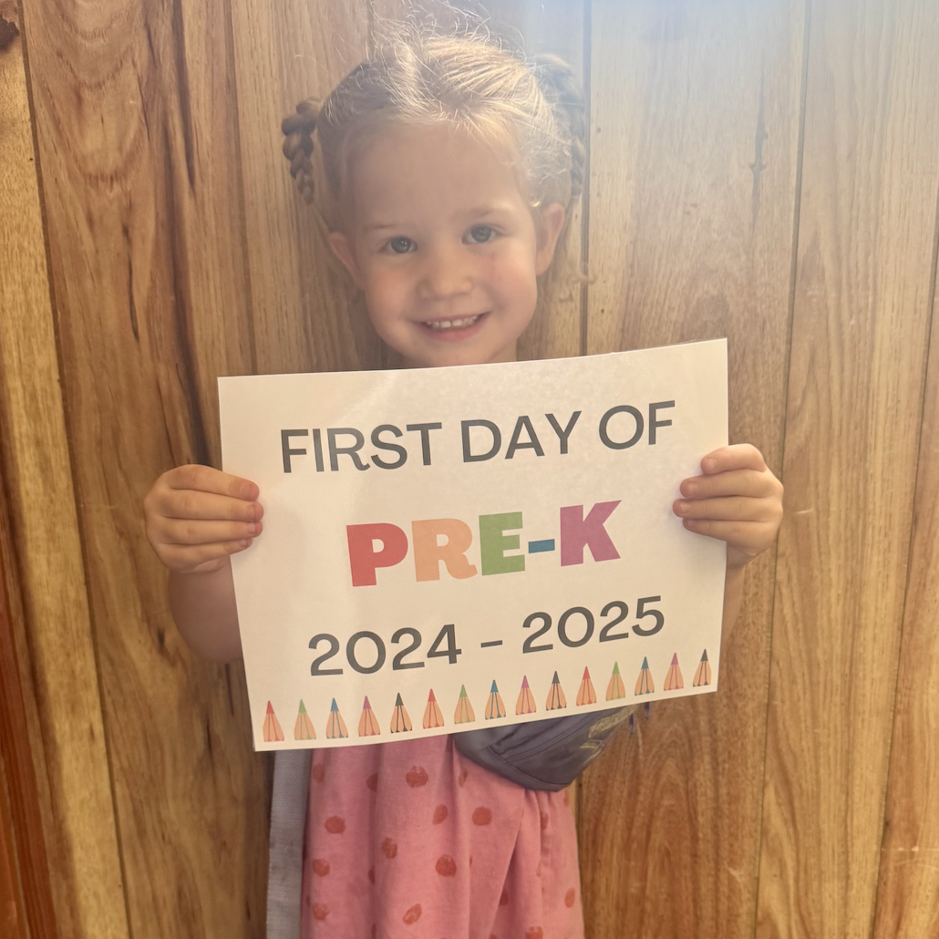 little girl holding 1st day of Pre-K sign