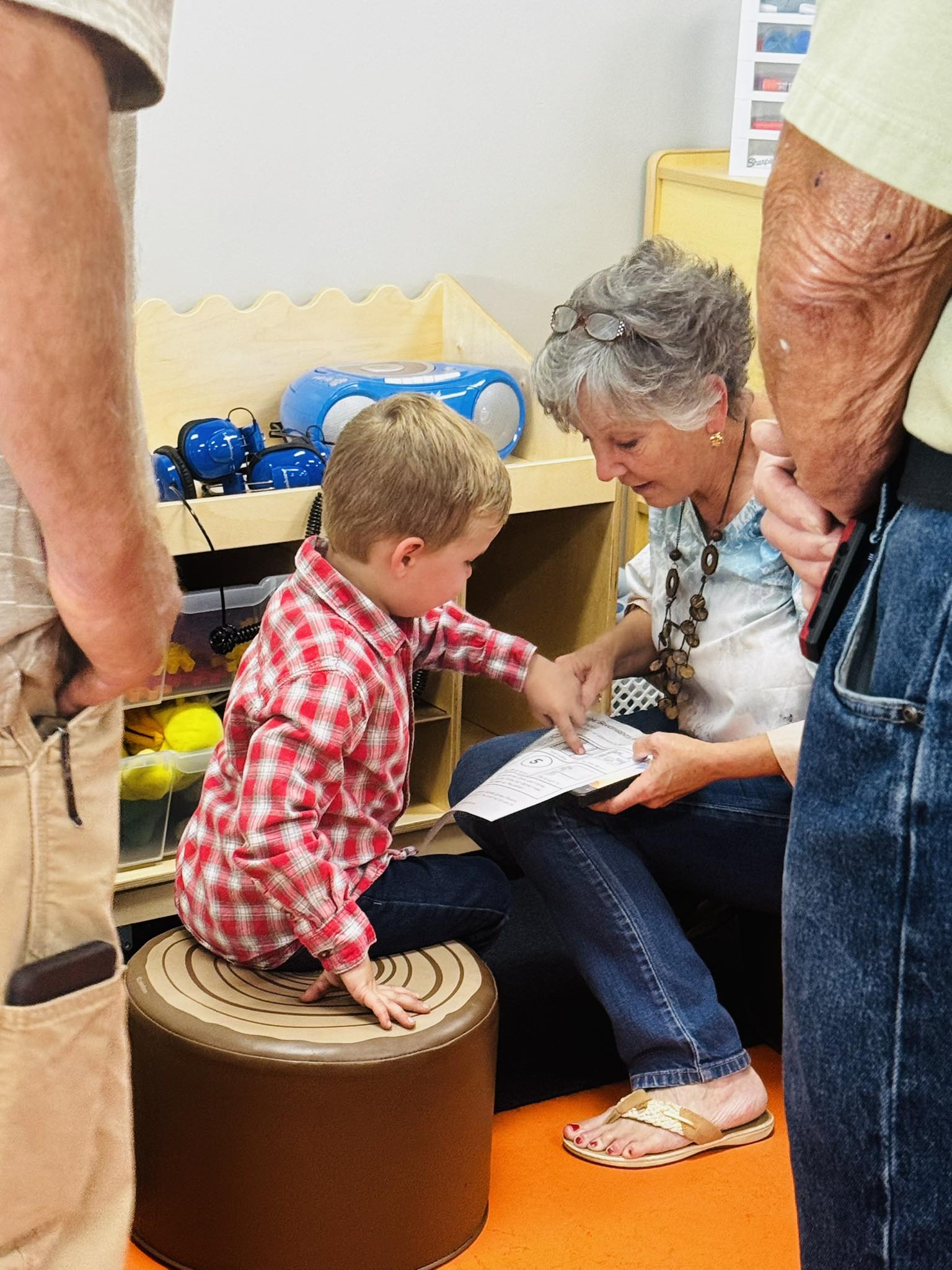 Student showing a grandparent something on a page