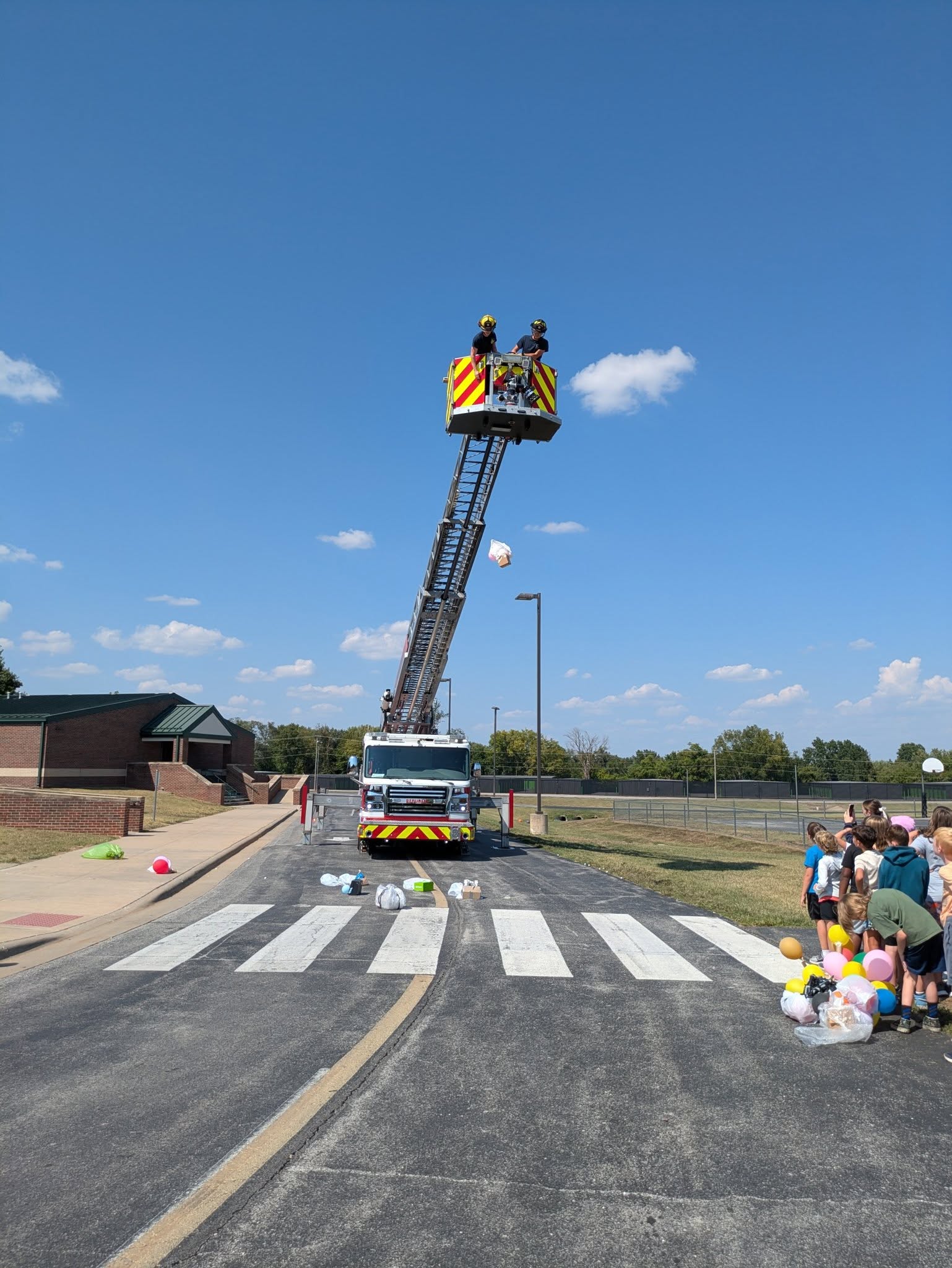 Firefighters dropping a box from their ladder truck