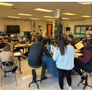 Teachers gathered around tables in a classroom