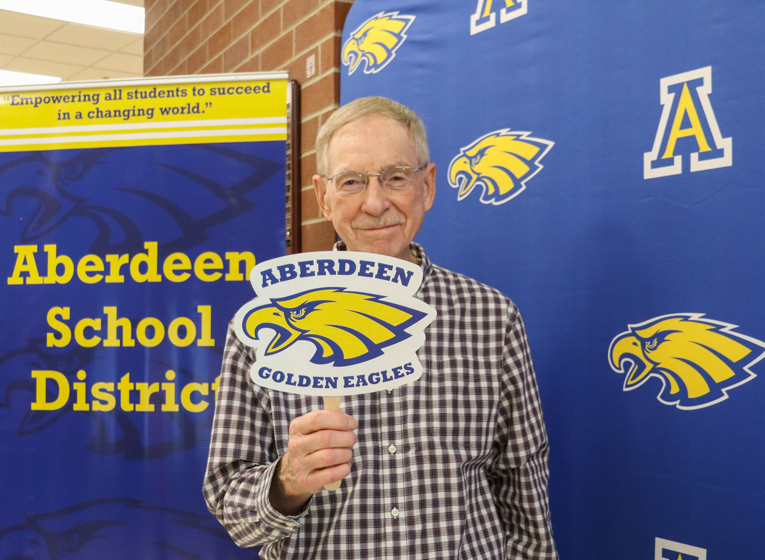 Duane Alm holding an  Aberdeen Golden Eagle sign