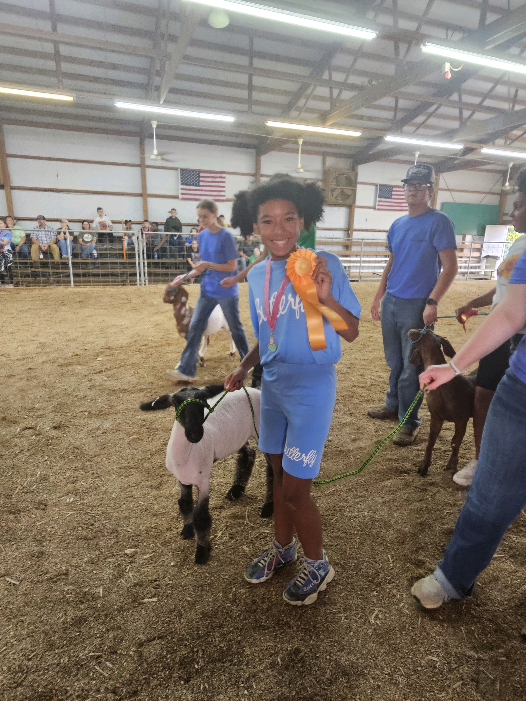 Henry Student showing of her robbon for showing her sheep at the Day of Champions.