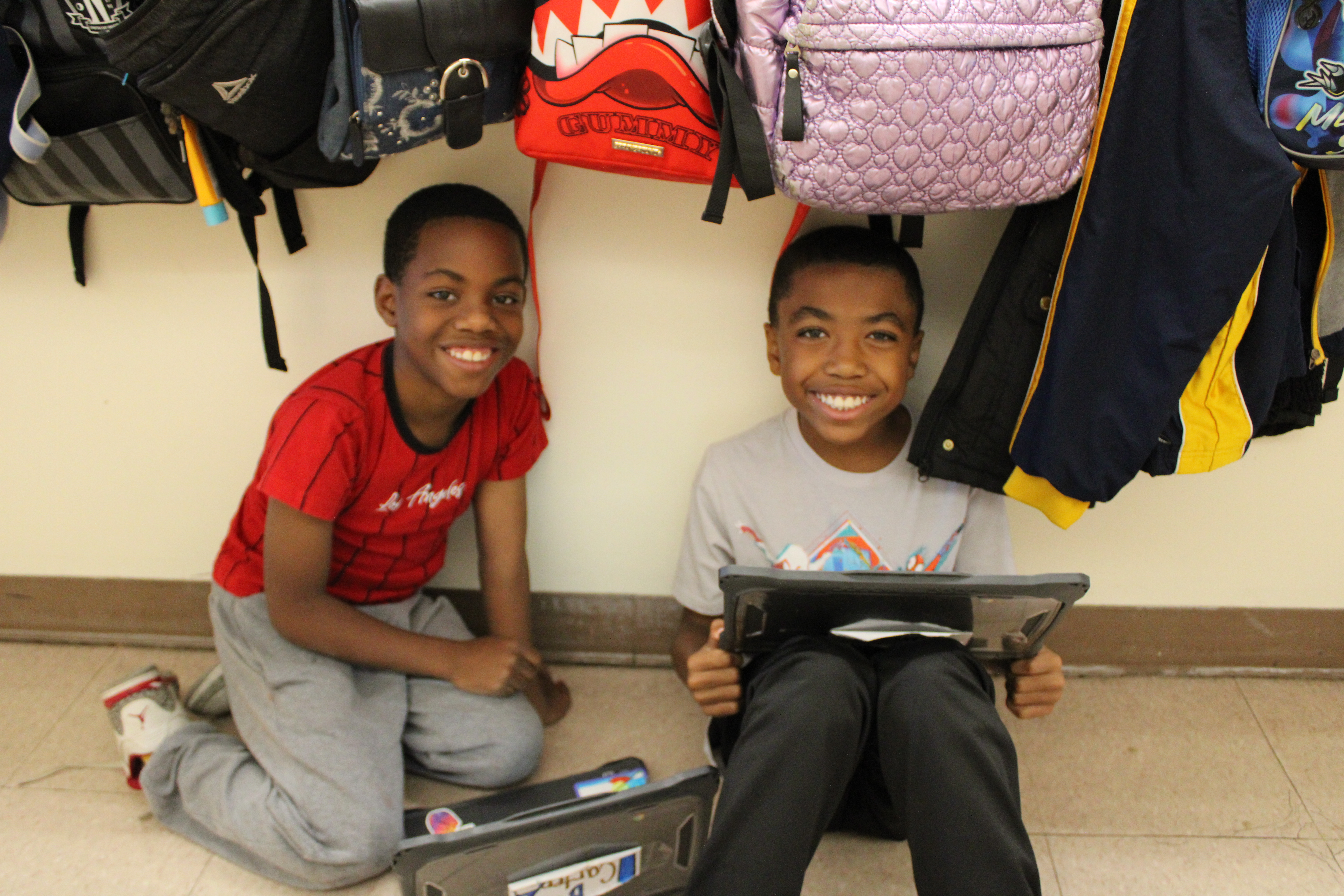 students on laptops sitting in hallways