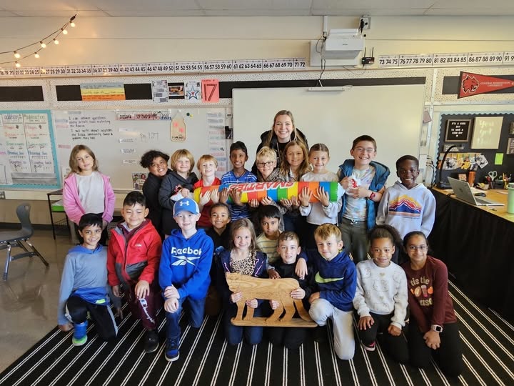 Mrs. Morgan's class posing for a photo with large smarties candy after earning the Cougar Award for September at Westwood Elementary