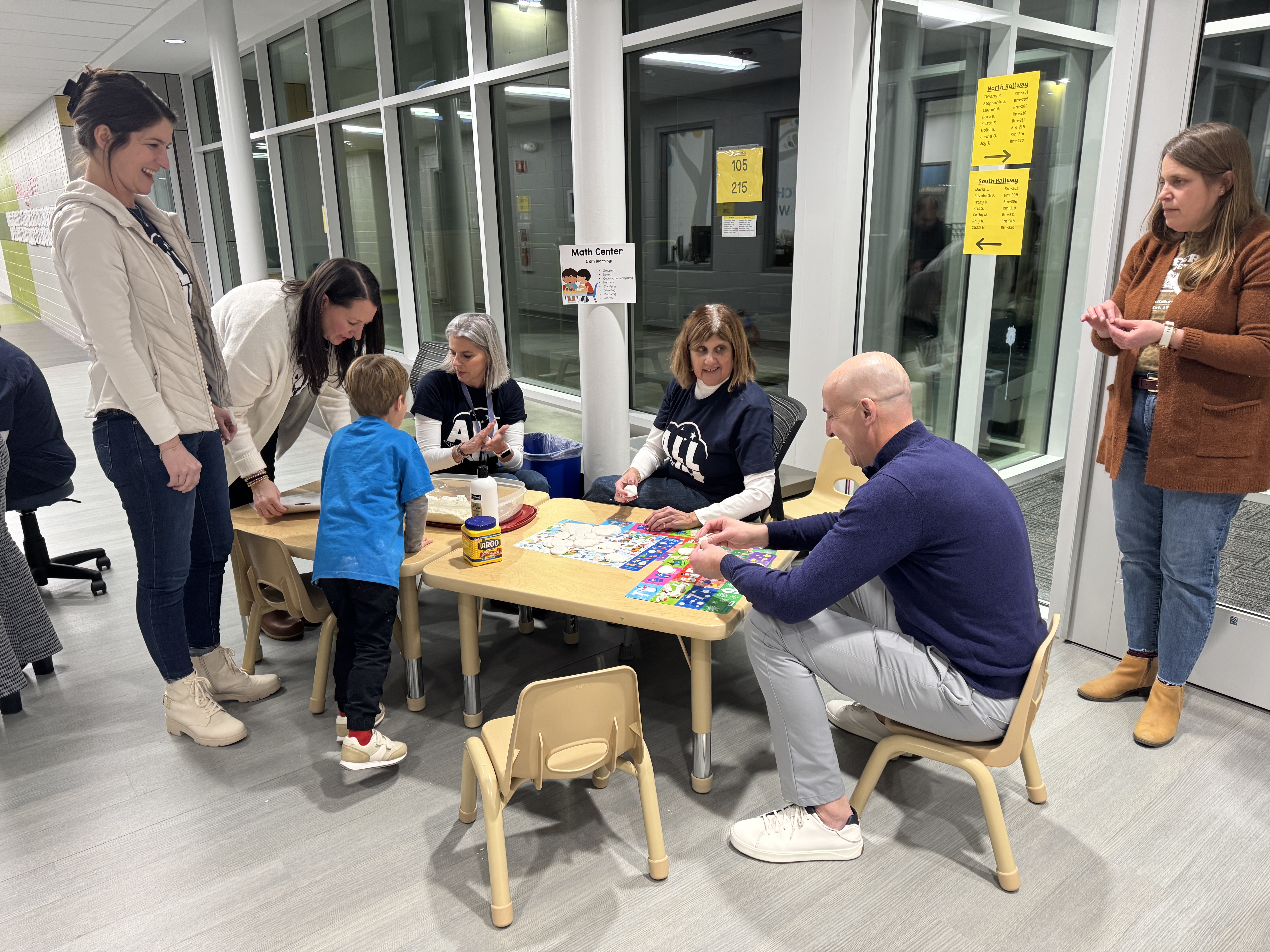 adults and students playing at a table