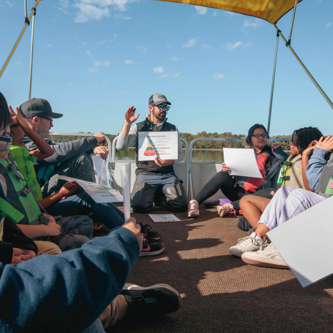 students on board the floating classroom, listening to instructions 