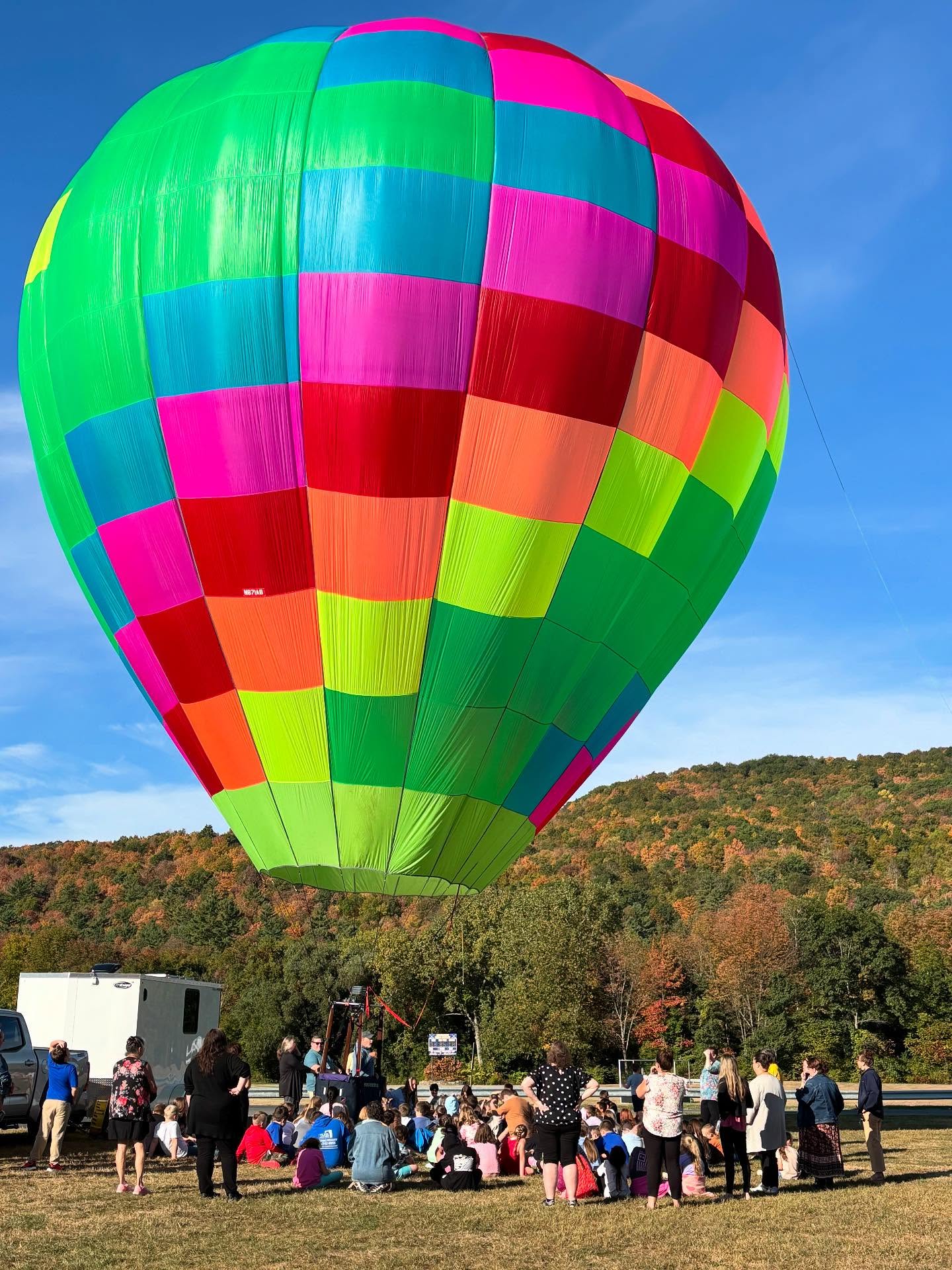 A picture of an inflated hot air ballon at GES surrounded by GES students 