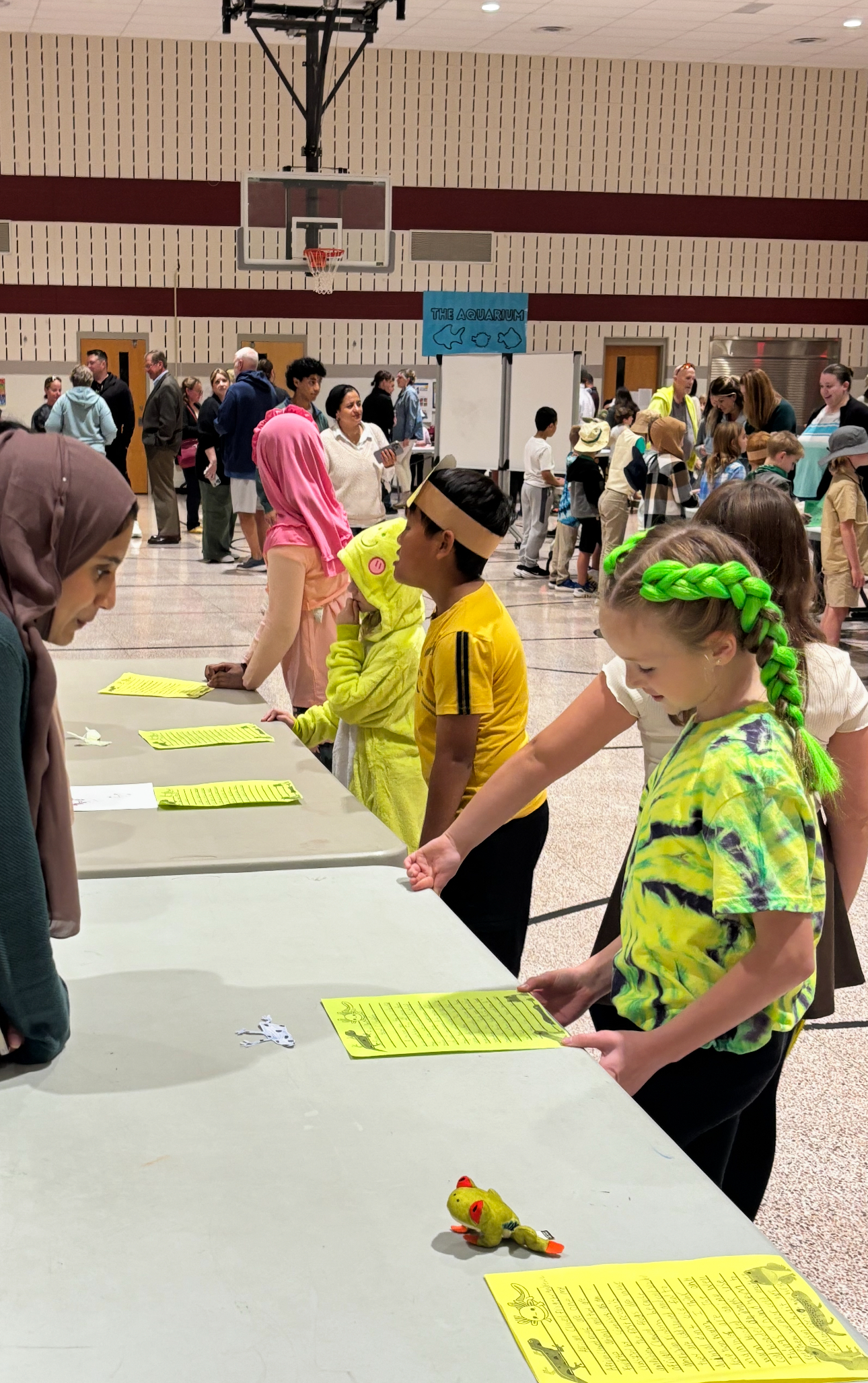 Photo of large multi-purpose room with students and parents.