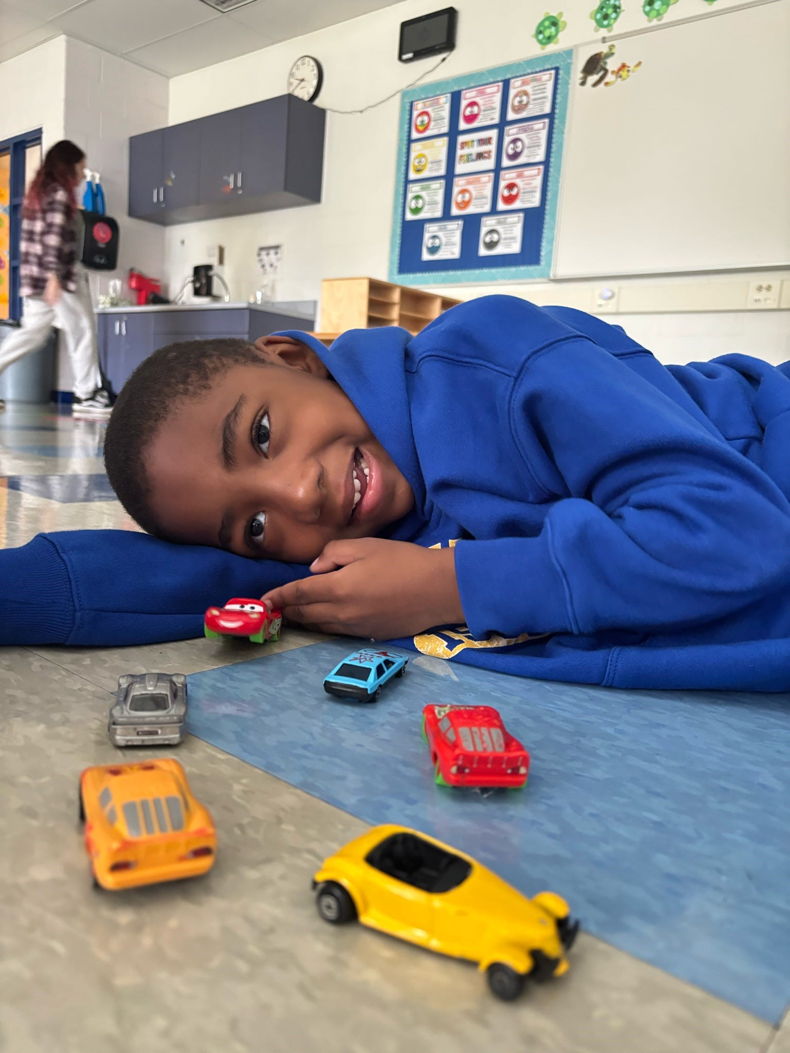 happy boy playing with cars