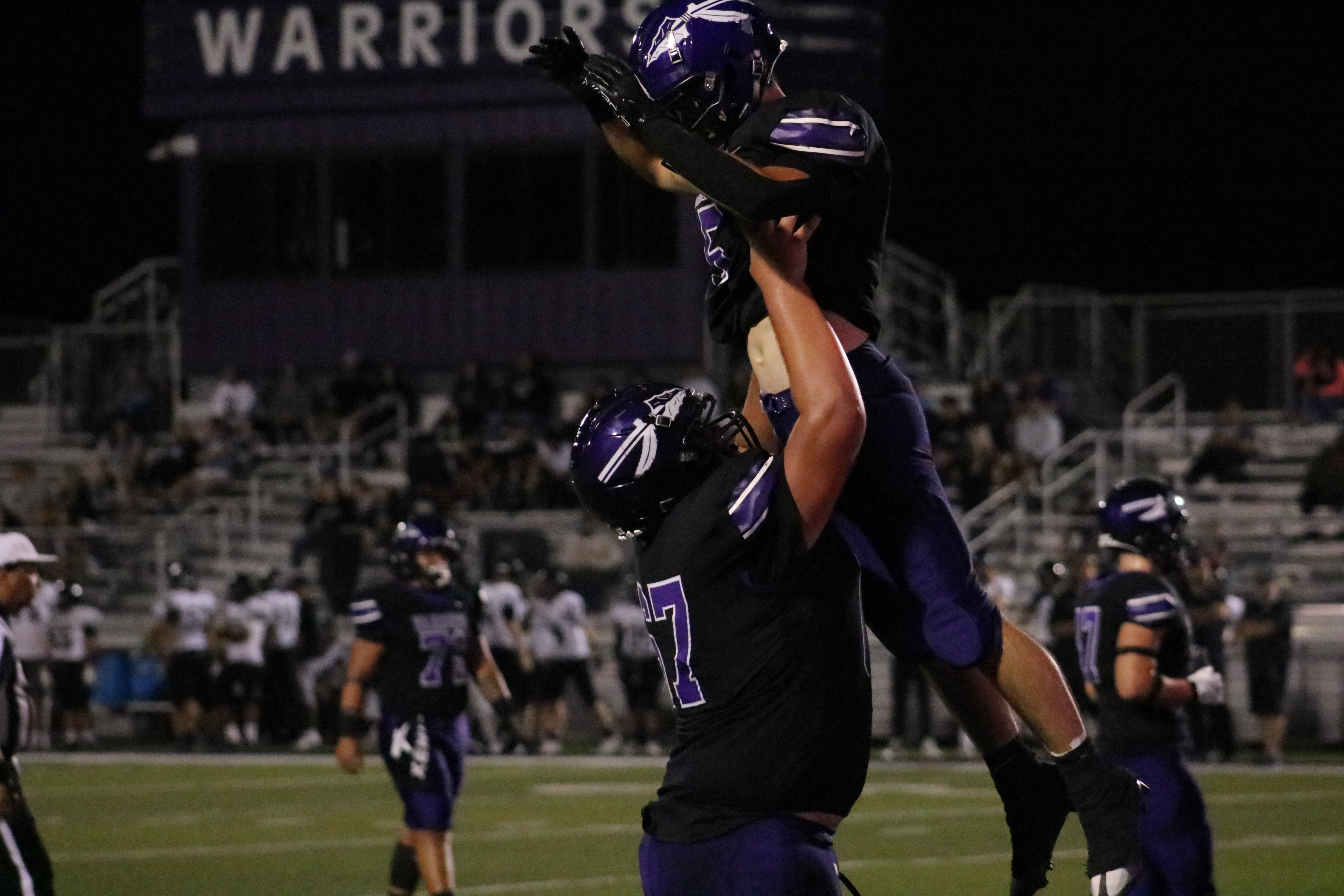 football player lifting another