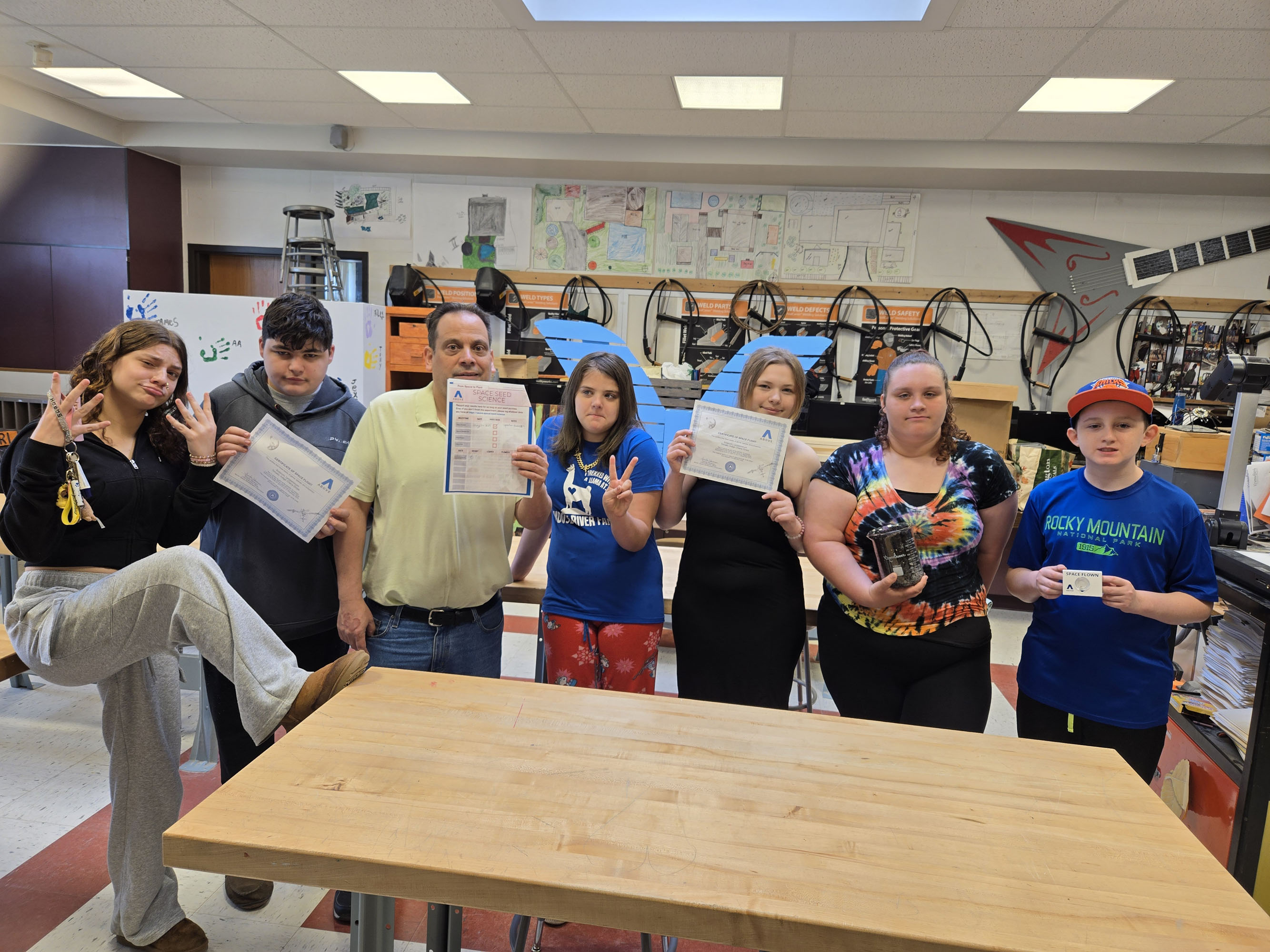 Students and science teacher with space seed capsule and certificate