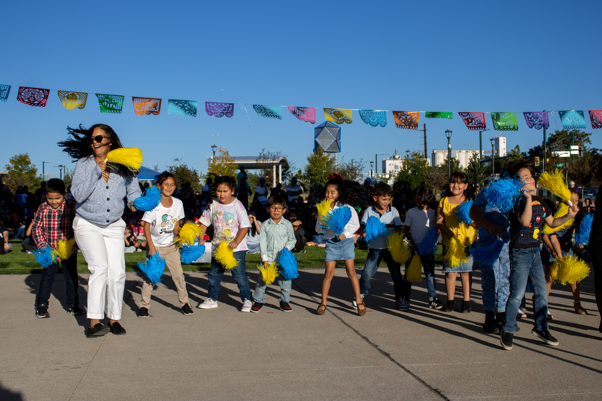 Ms. Marquez and her class perform a routine at Fiesta Hispana with pom poms. 