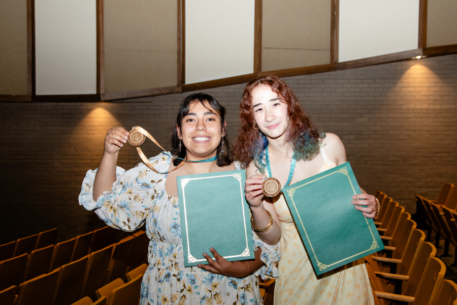 two students showing of their medals at the spring ceremony