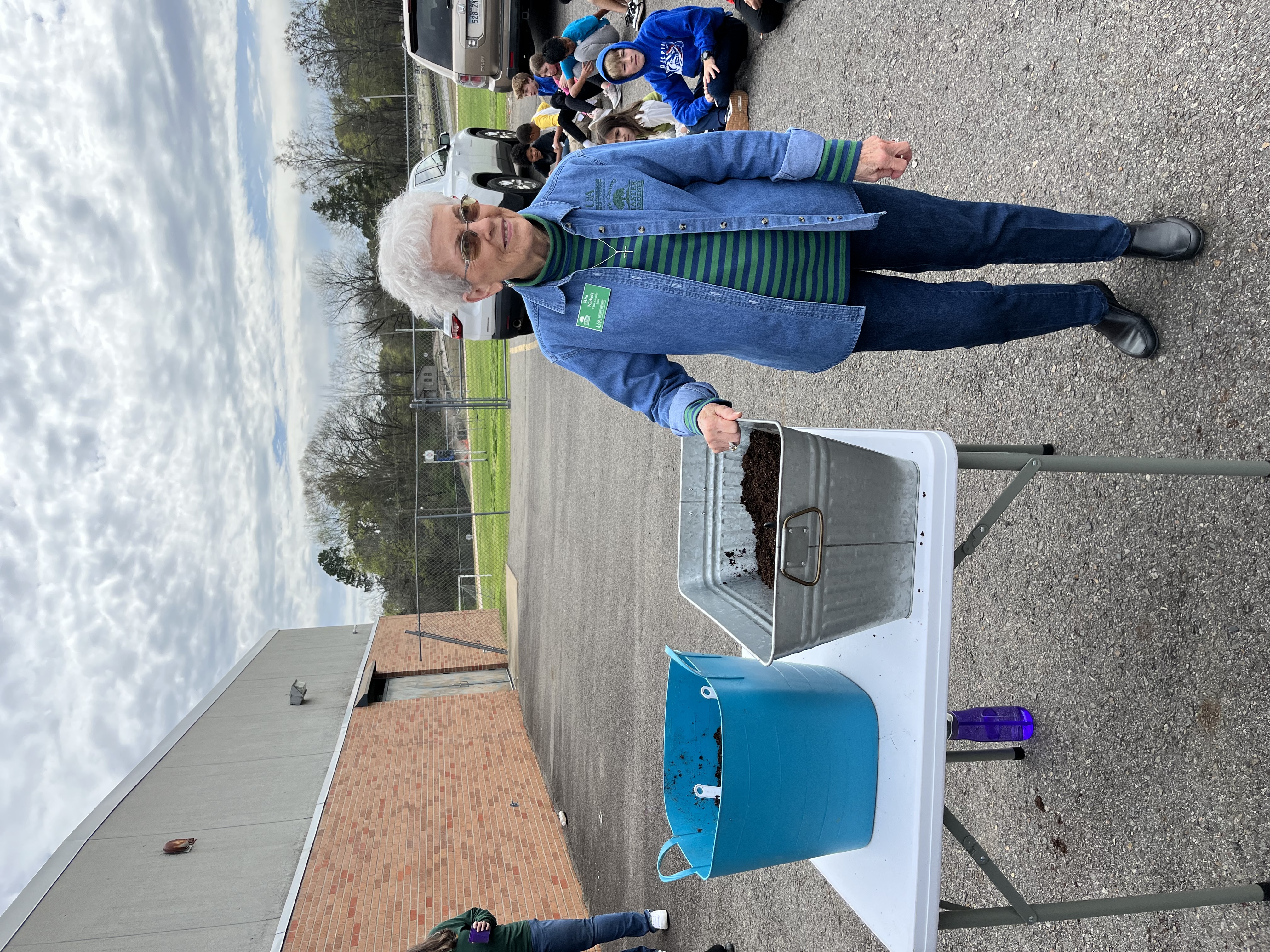 Master Gardeners helping students plant seeds