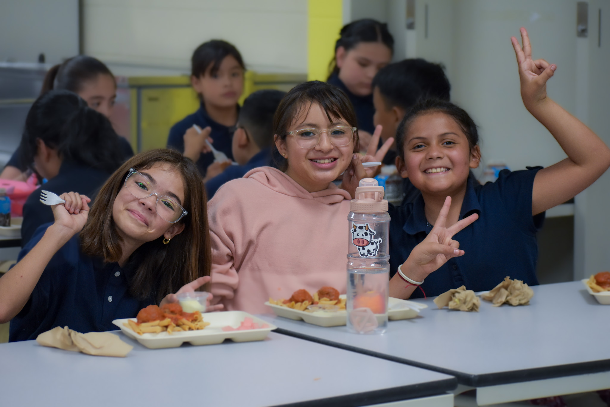 Students smile in the lunchroom. 