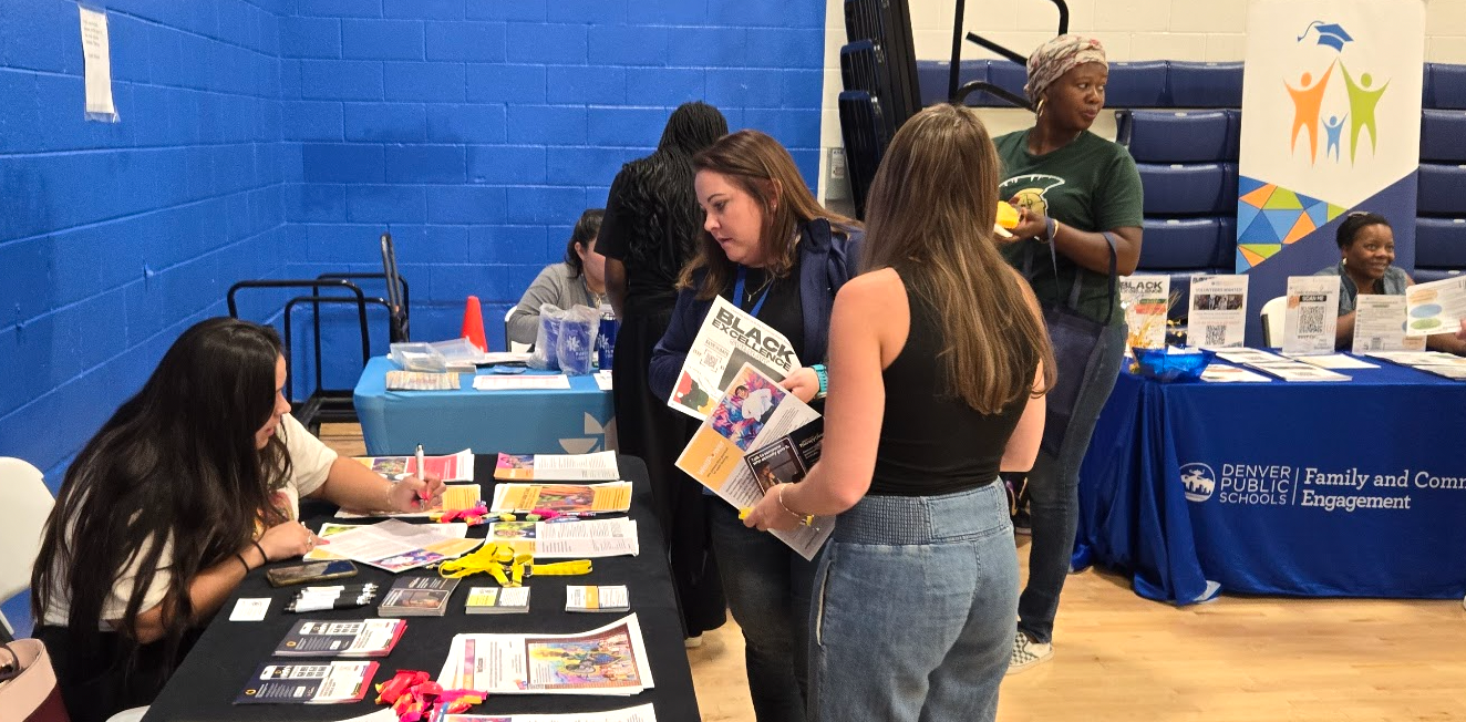 students stopping at a table in the gym