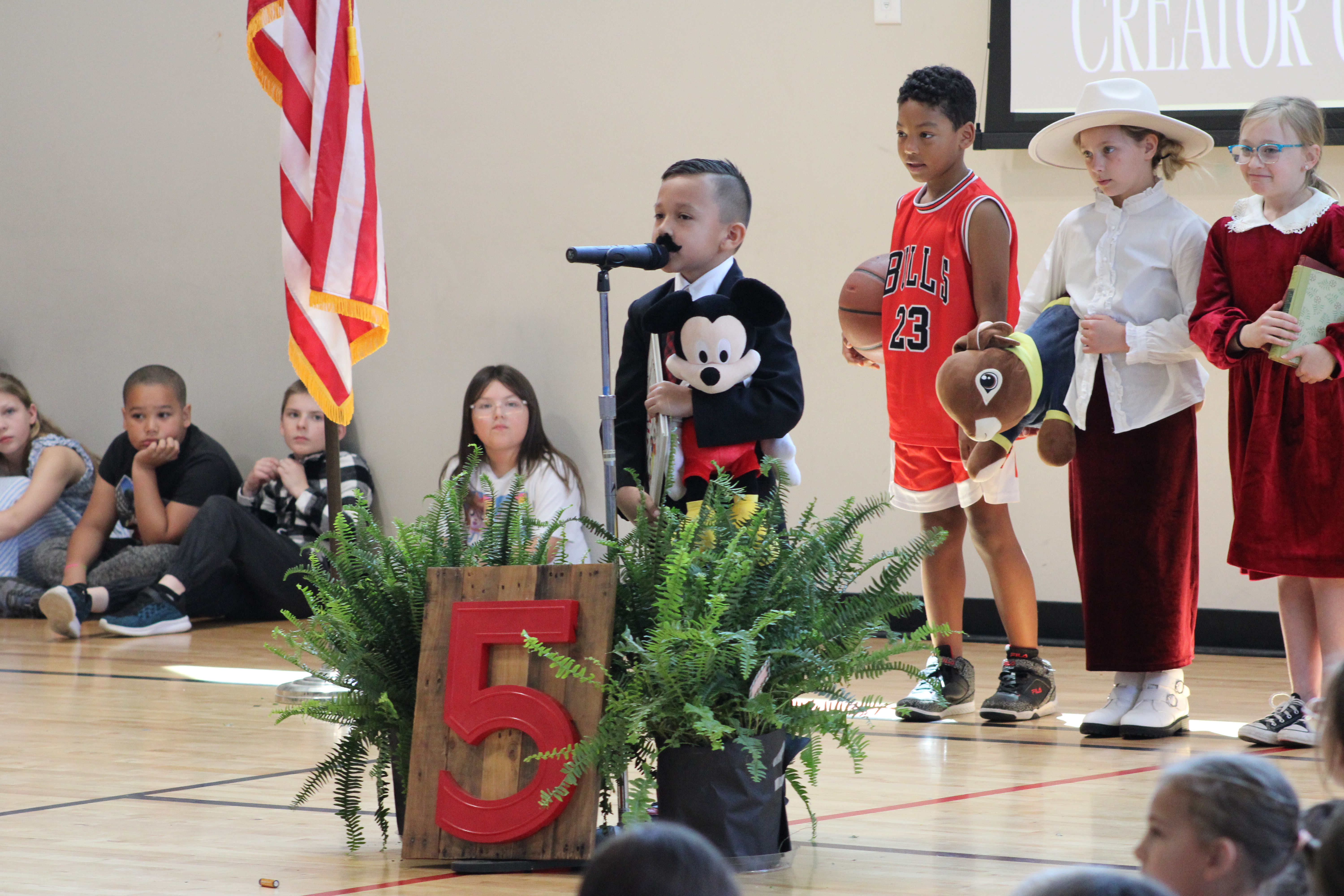 Student portraying Walt Disney during GE assembly