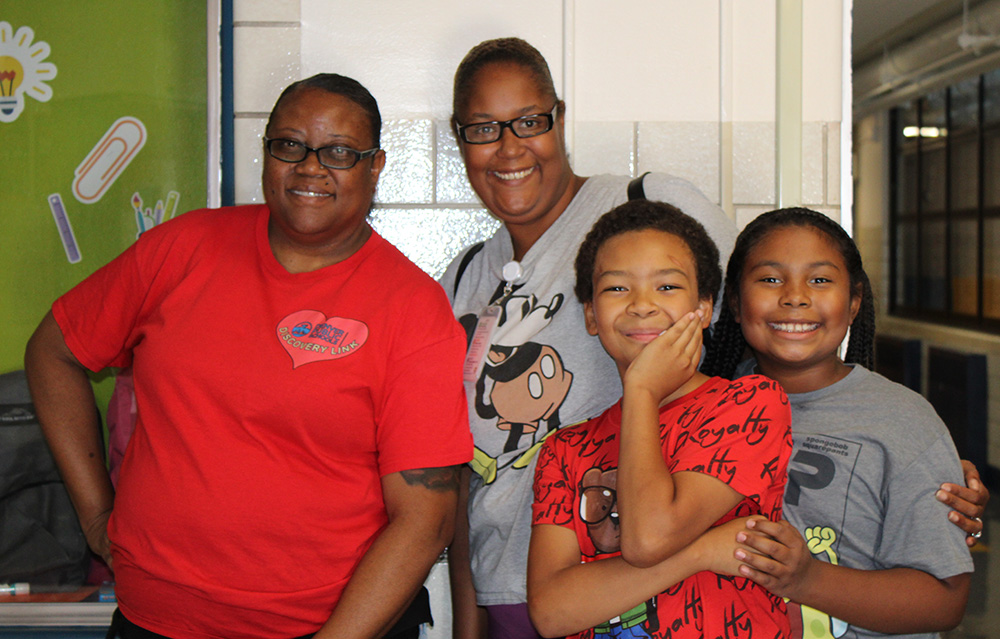 staff and students smiling at the camera