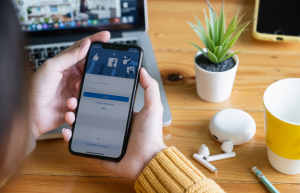 Person holding phone with facebook app open