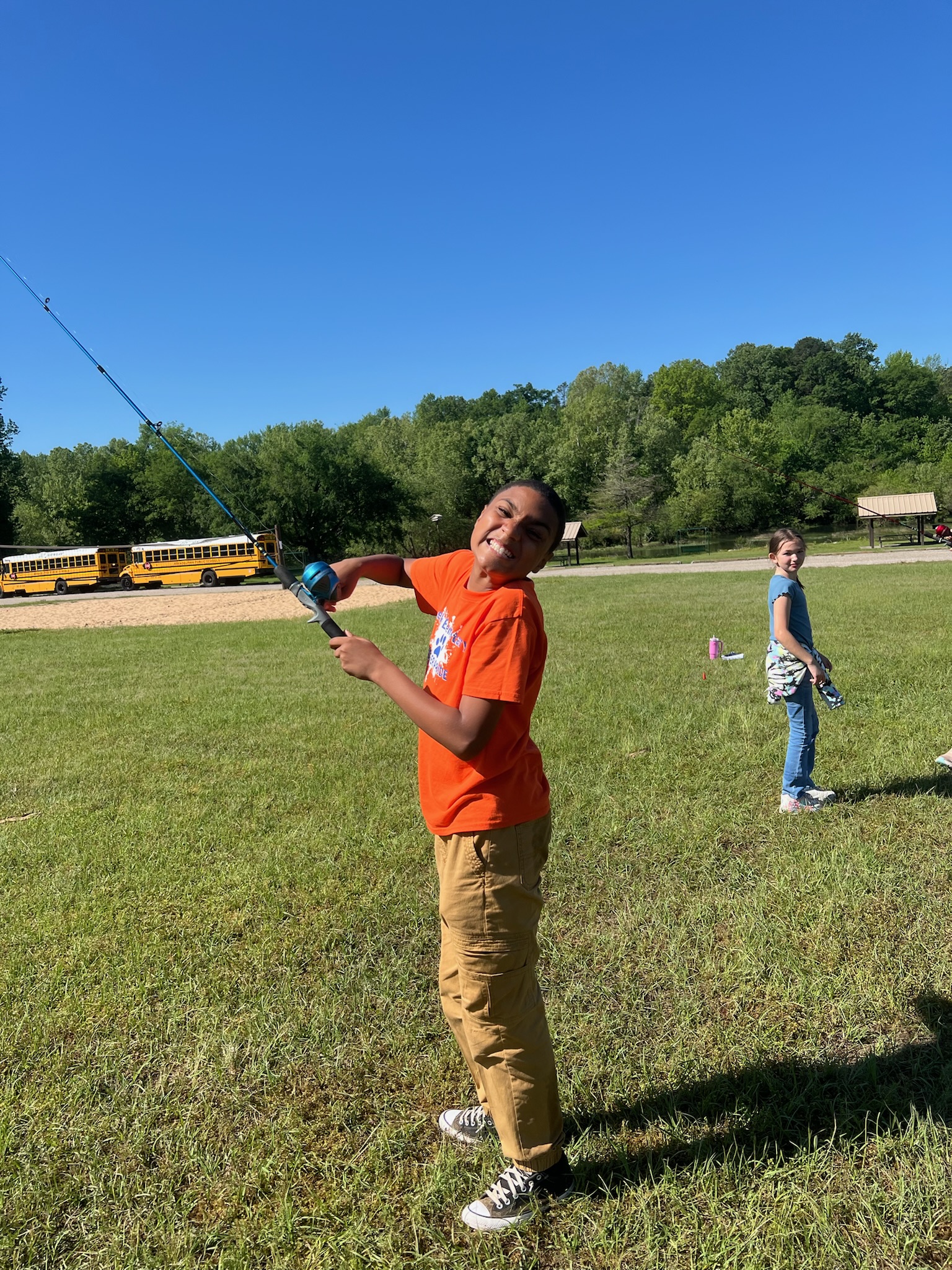 student smiling with a fishing pole