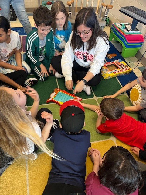 Students sitting around teacher