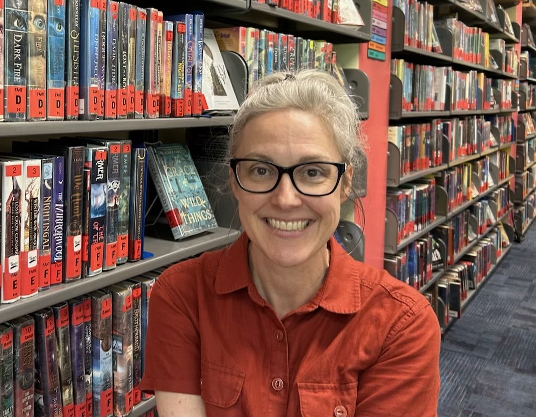 Brandie Burrows standing next to library books