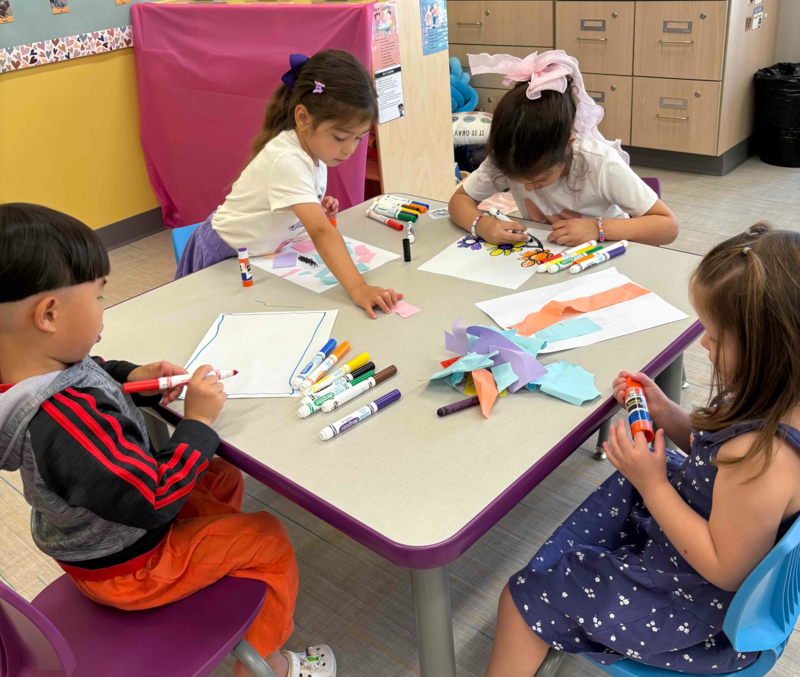 Children working with markers on a table