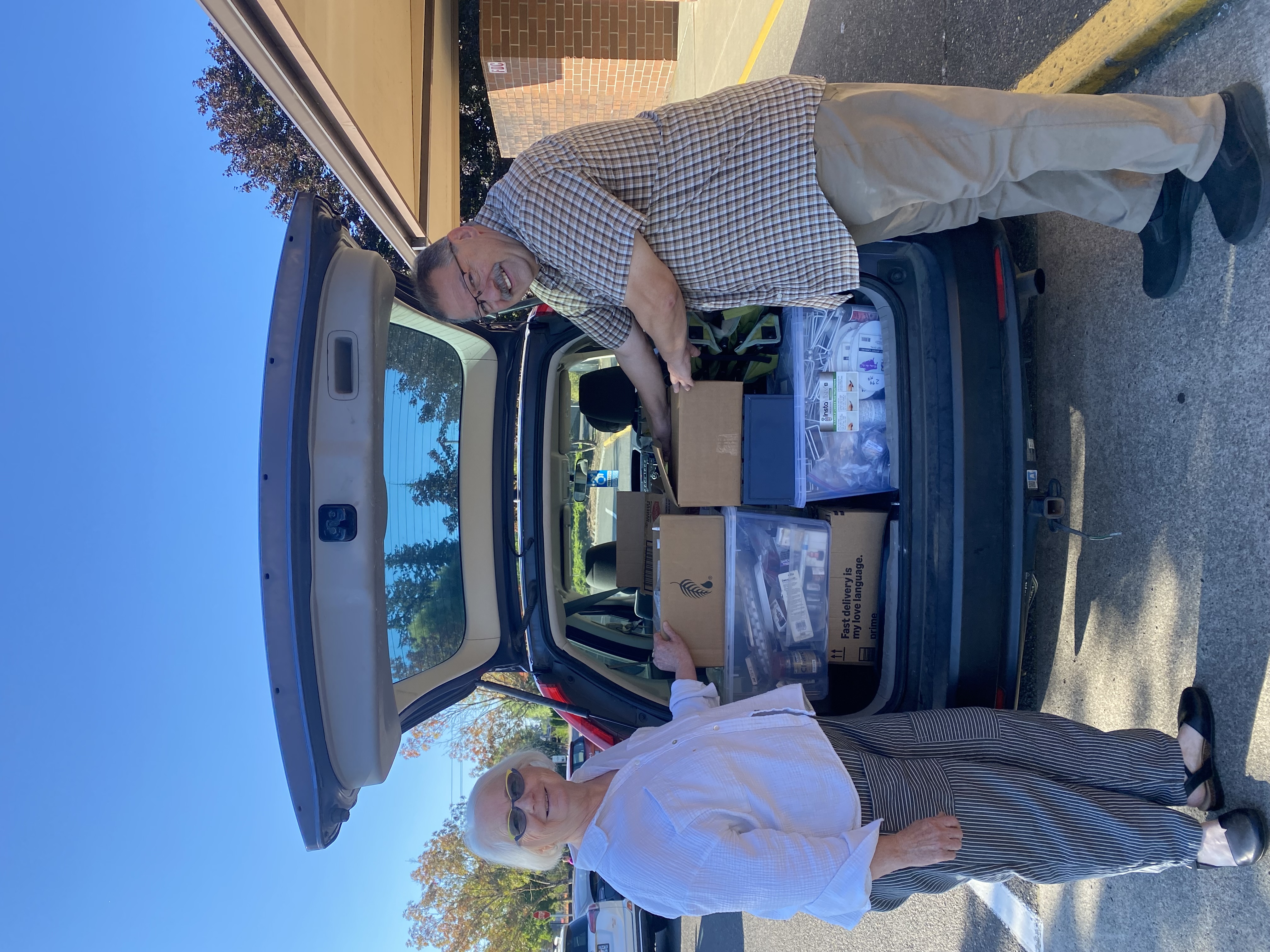 Members of the Battle Ground Art Alliance unload a car packed with donated supplies