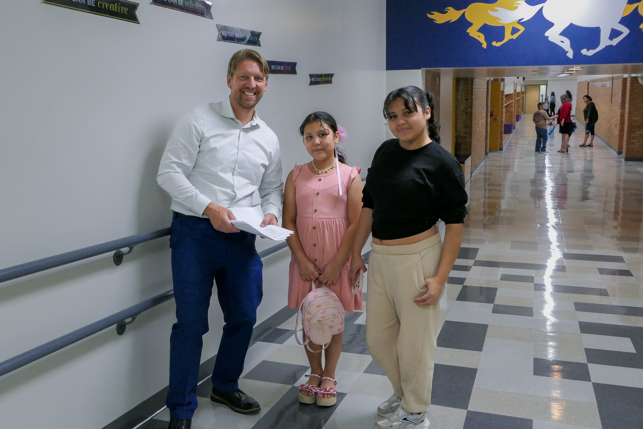 Mr. Bailey and two students smile for a photo.