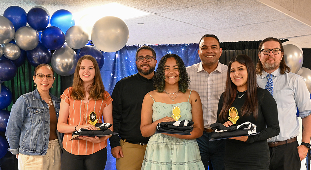 Students holding award trophies