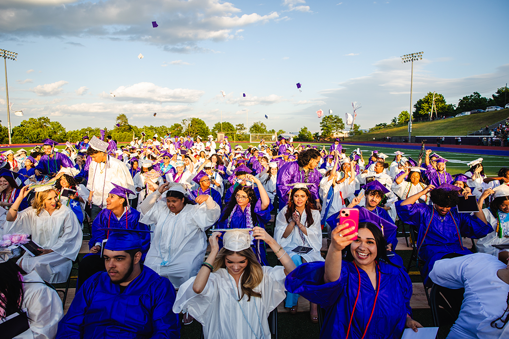 Graduates on football field during ceremony