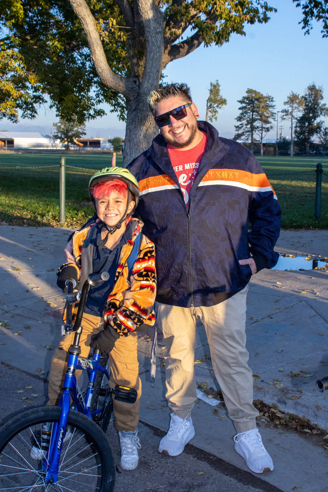 A student poses with his father and bike. 
