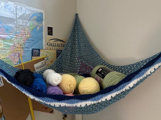 crocheted 3 point shelf holding skeins of yarn
