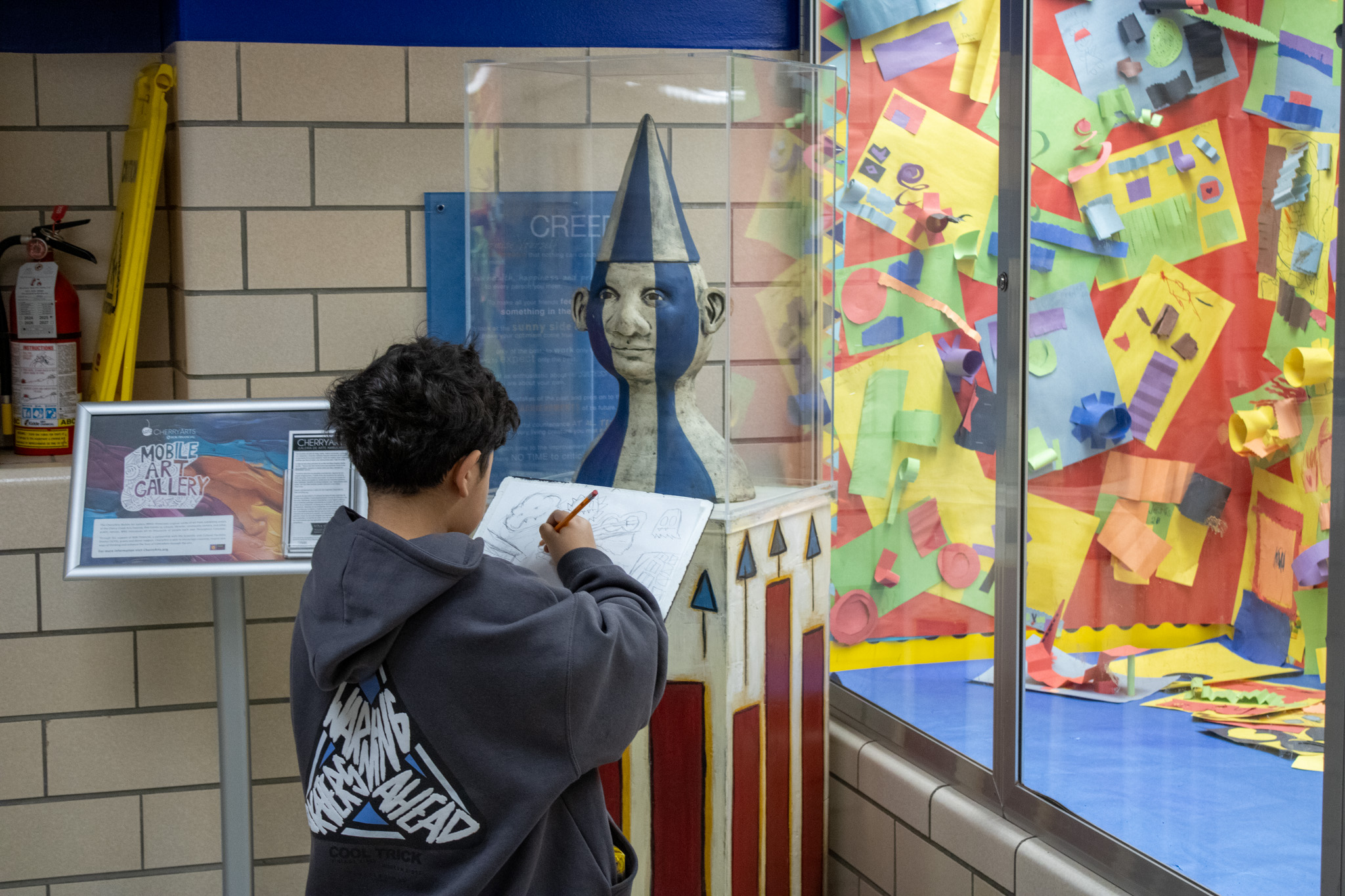 A student admires an exhibit from the Cherry Arts Mobile Gallery.