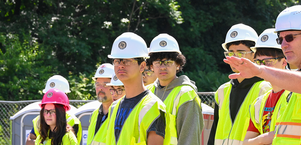 High school students wearing hard hats and safety vests