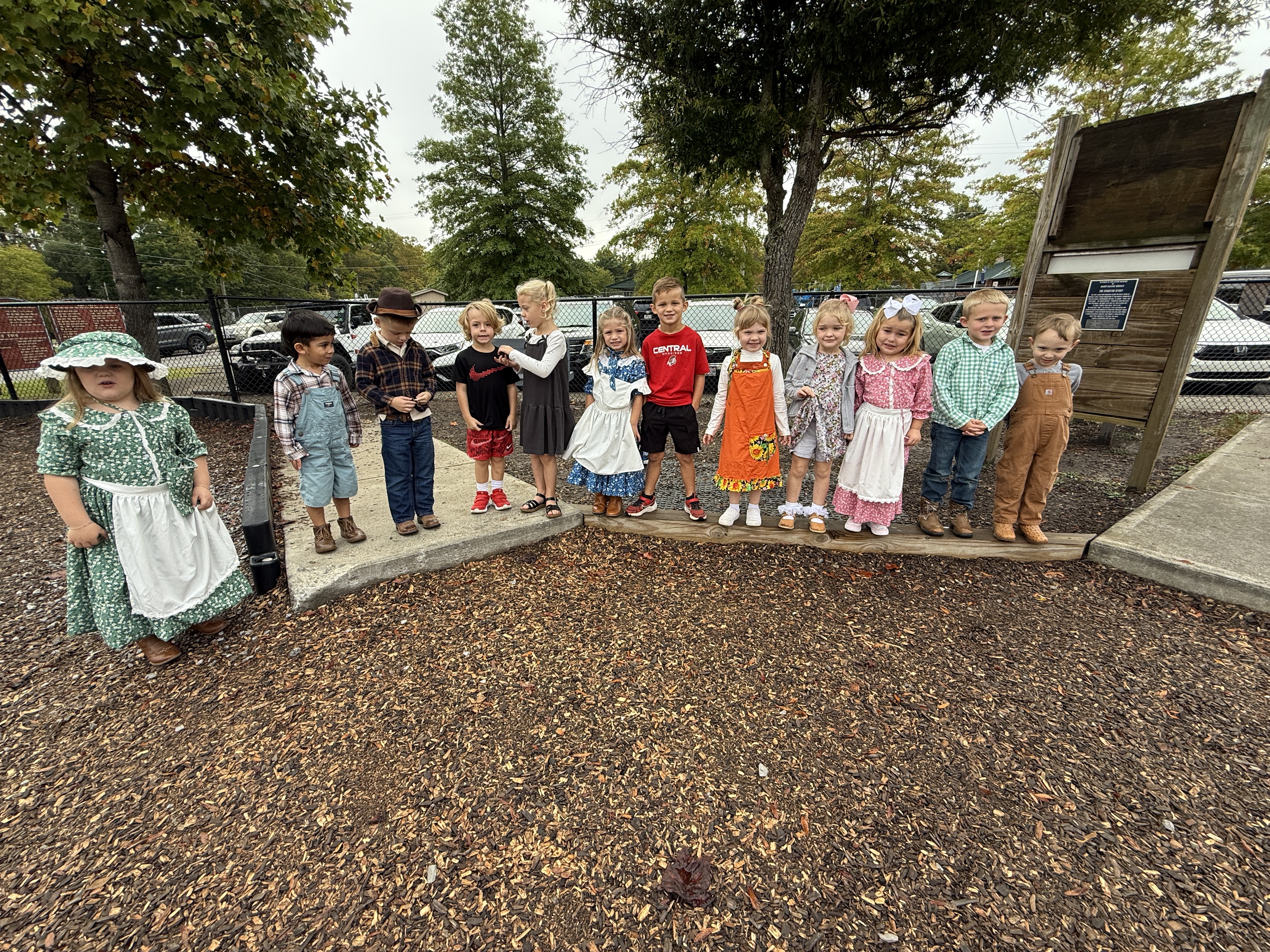 Students pose for a group photo in front of a tractor