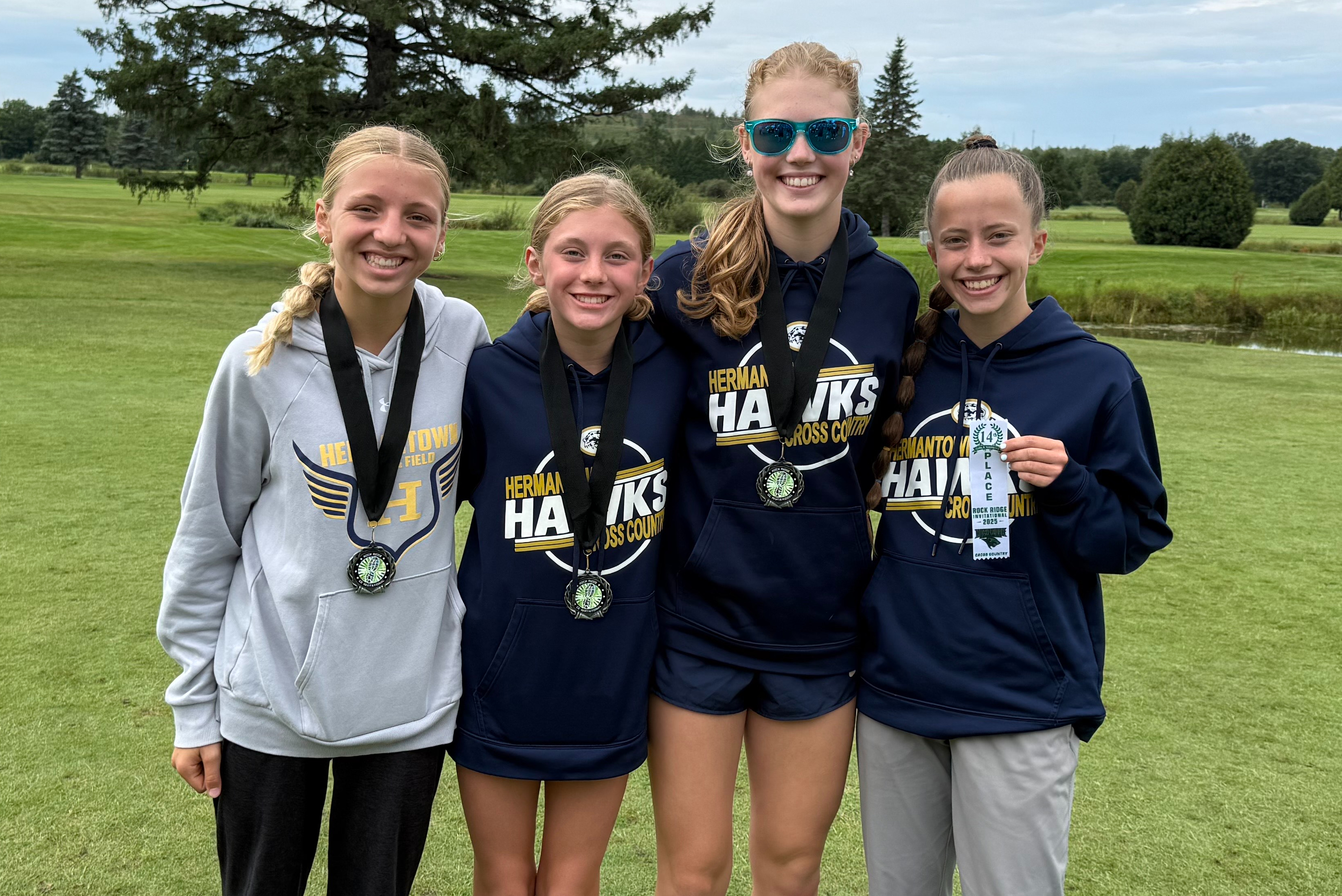girls cross country runners holding their awards