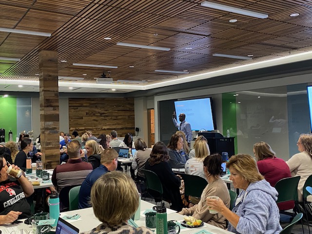 counselors in a room with kevin summey at the head of the room doing a presentation