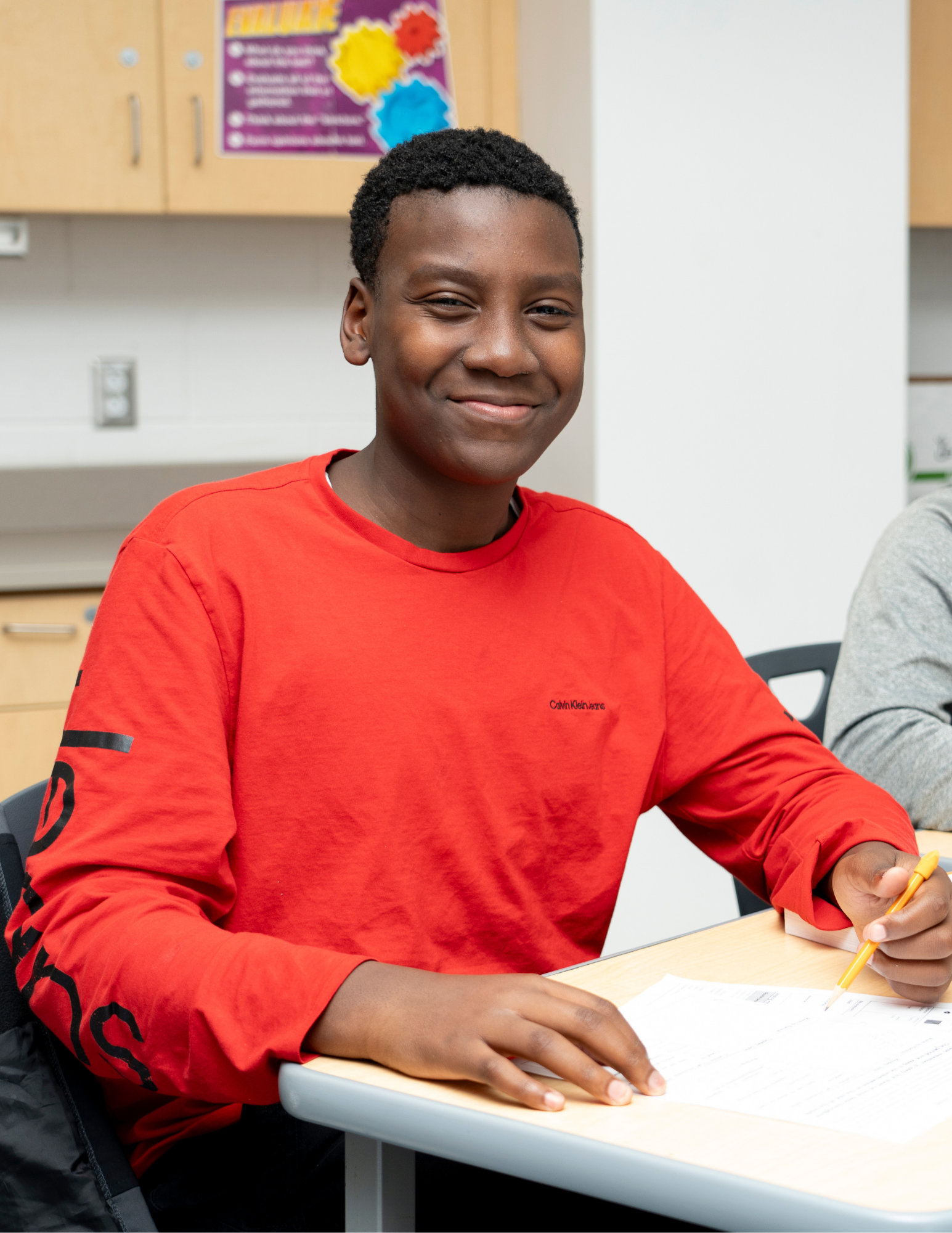 Estudiante escribe con en su pupitre