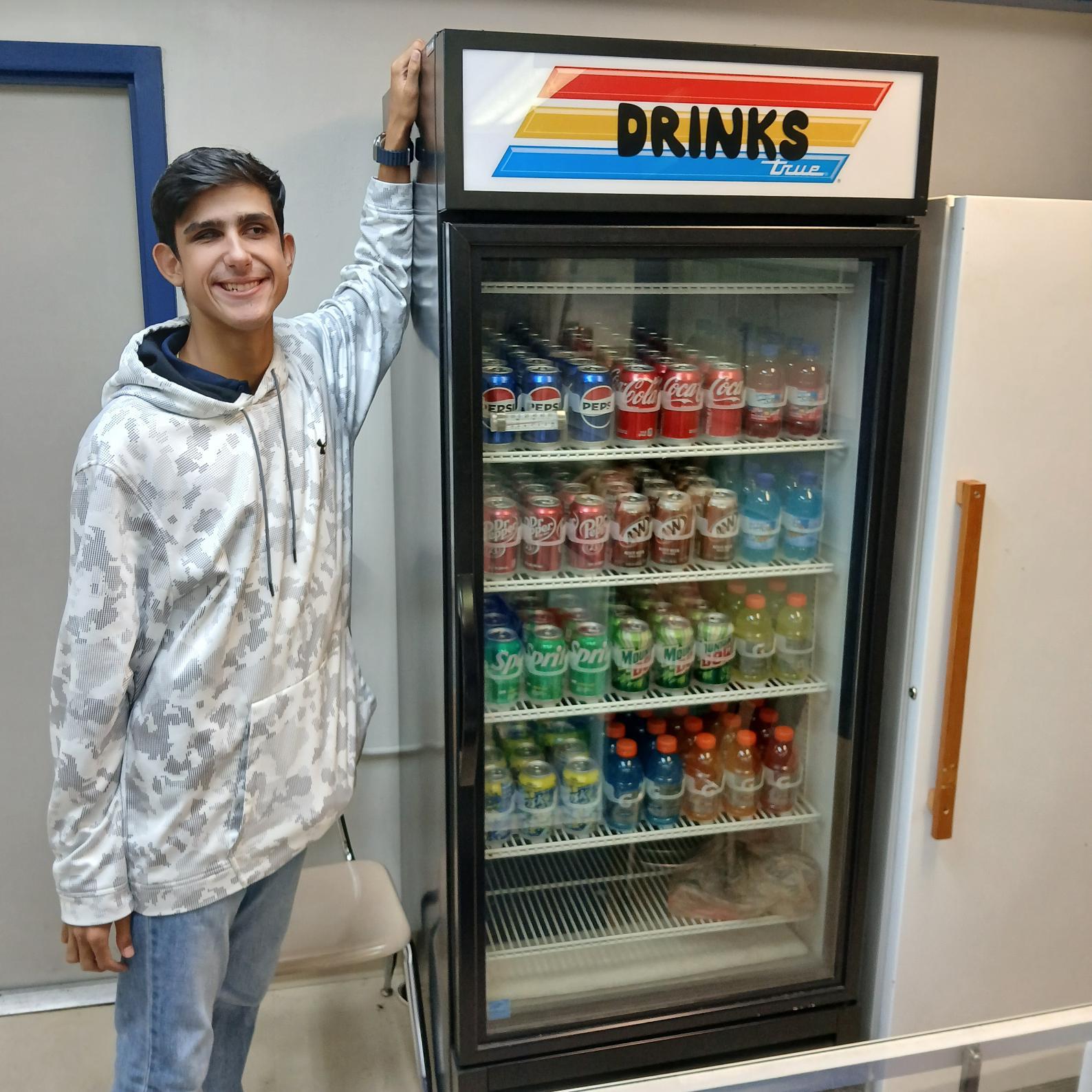 Damian standing beside drink cooler