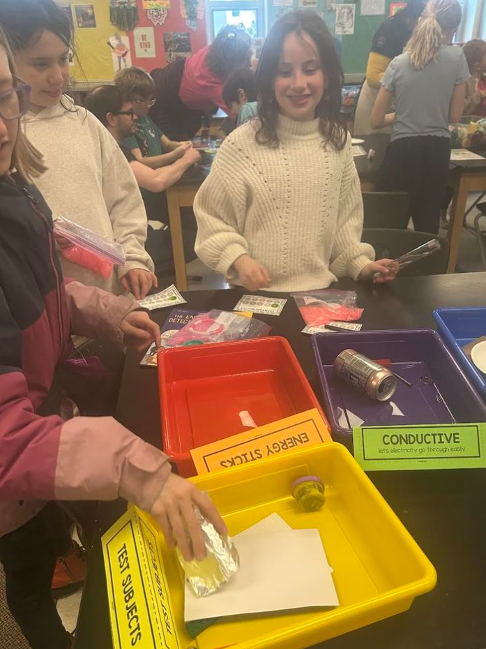 Students placing items in plastic bins