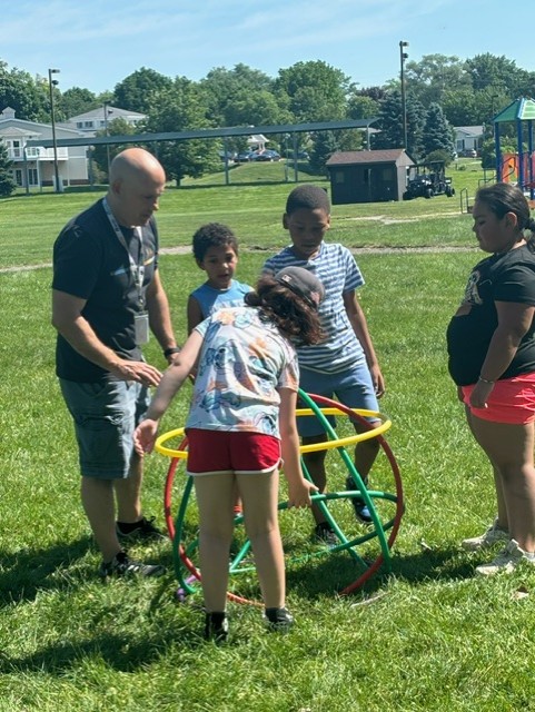 Teacher with students using hula hoops