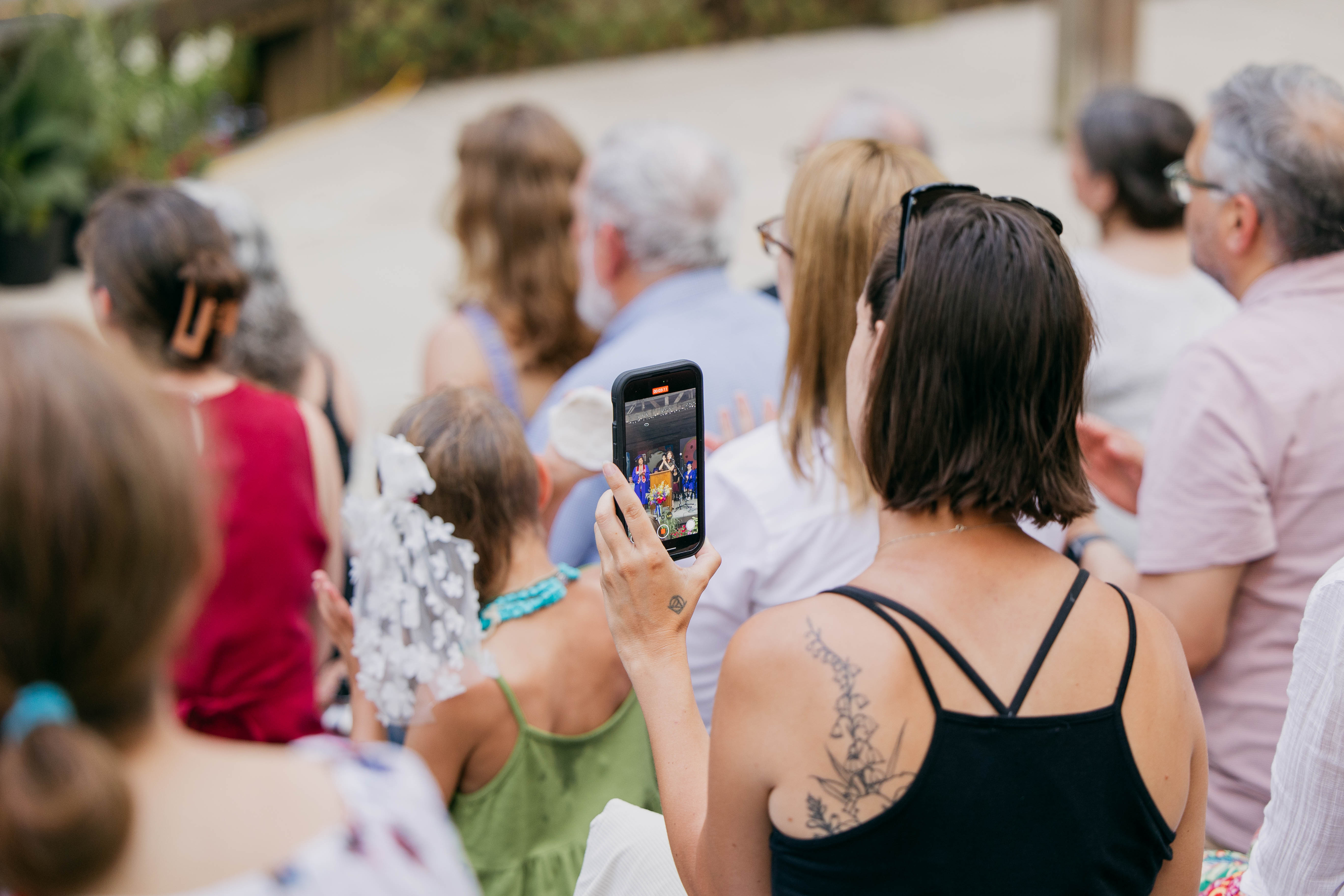 Person in the crowd recording a video on her phone