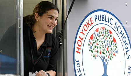 smiling woman leaning out window of food truck with HPS logo