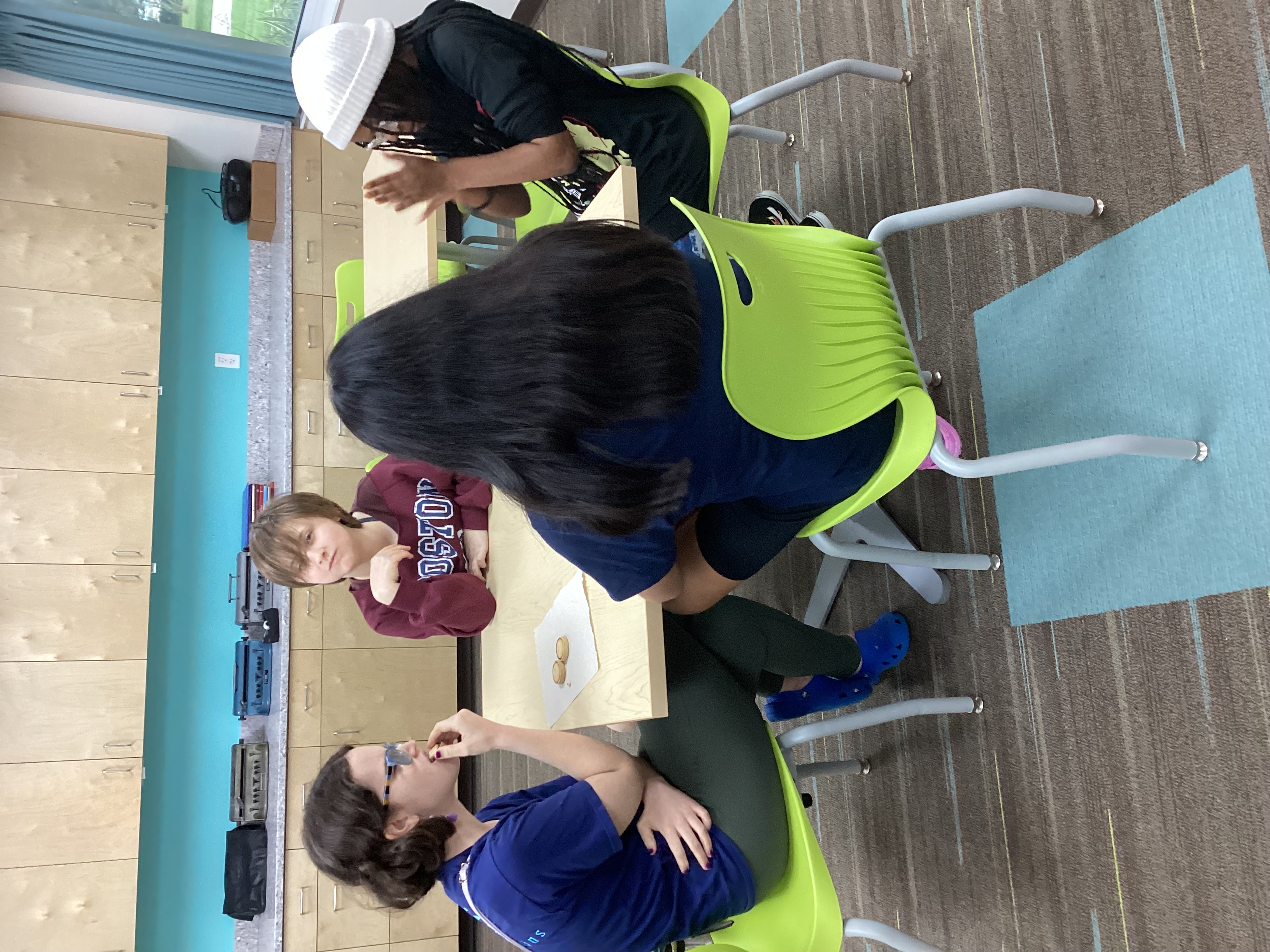 Hope, Meadow, Juana, and Serraya sitting at a table while socializing