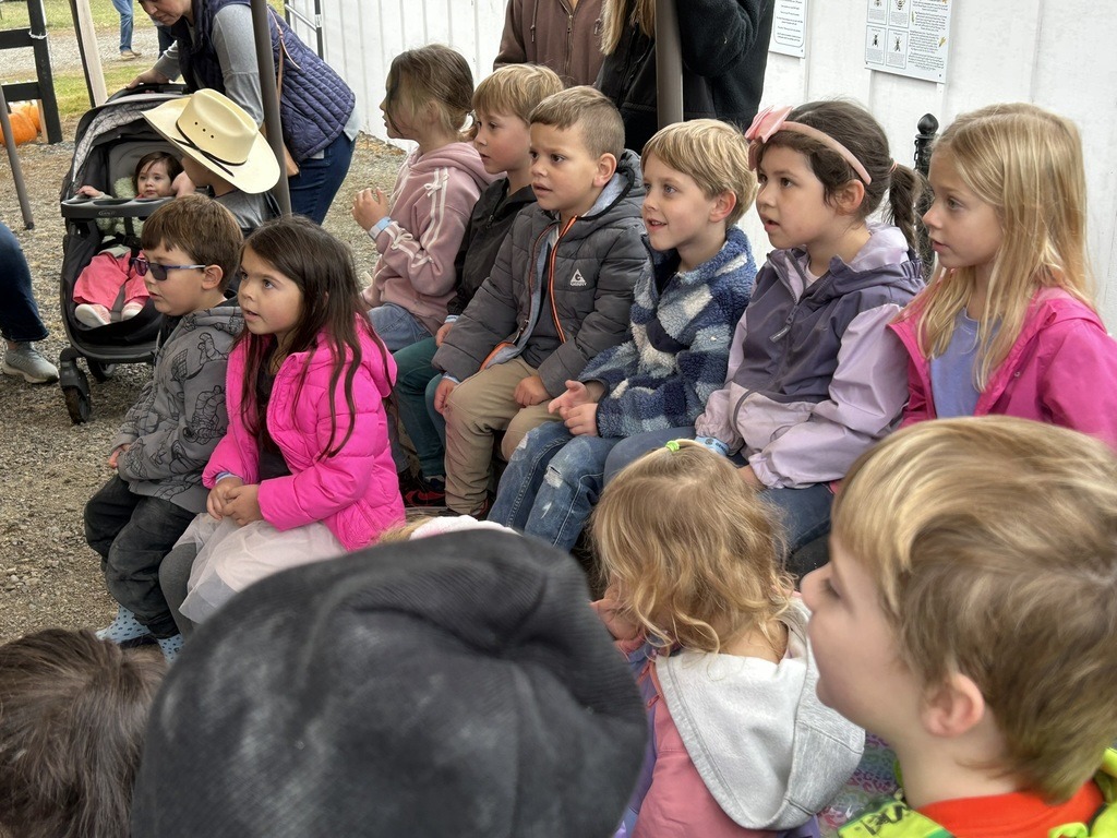 Elementary students listening to presentation on pumpkins at local pumpkin patch