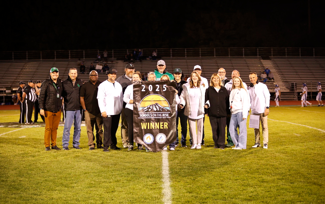a group gathered on a football field holding an award