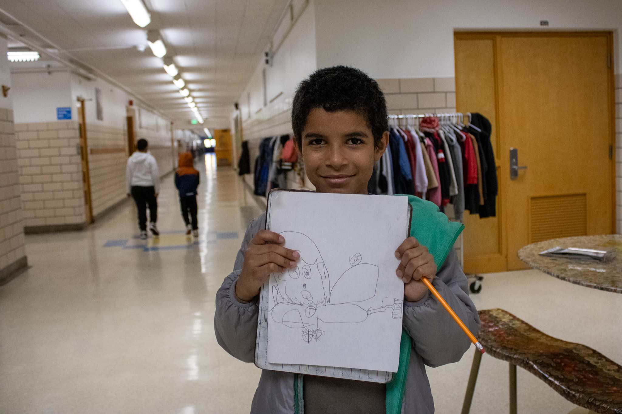 A student holds up their artwork.