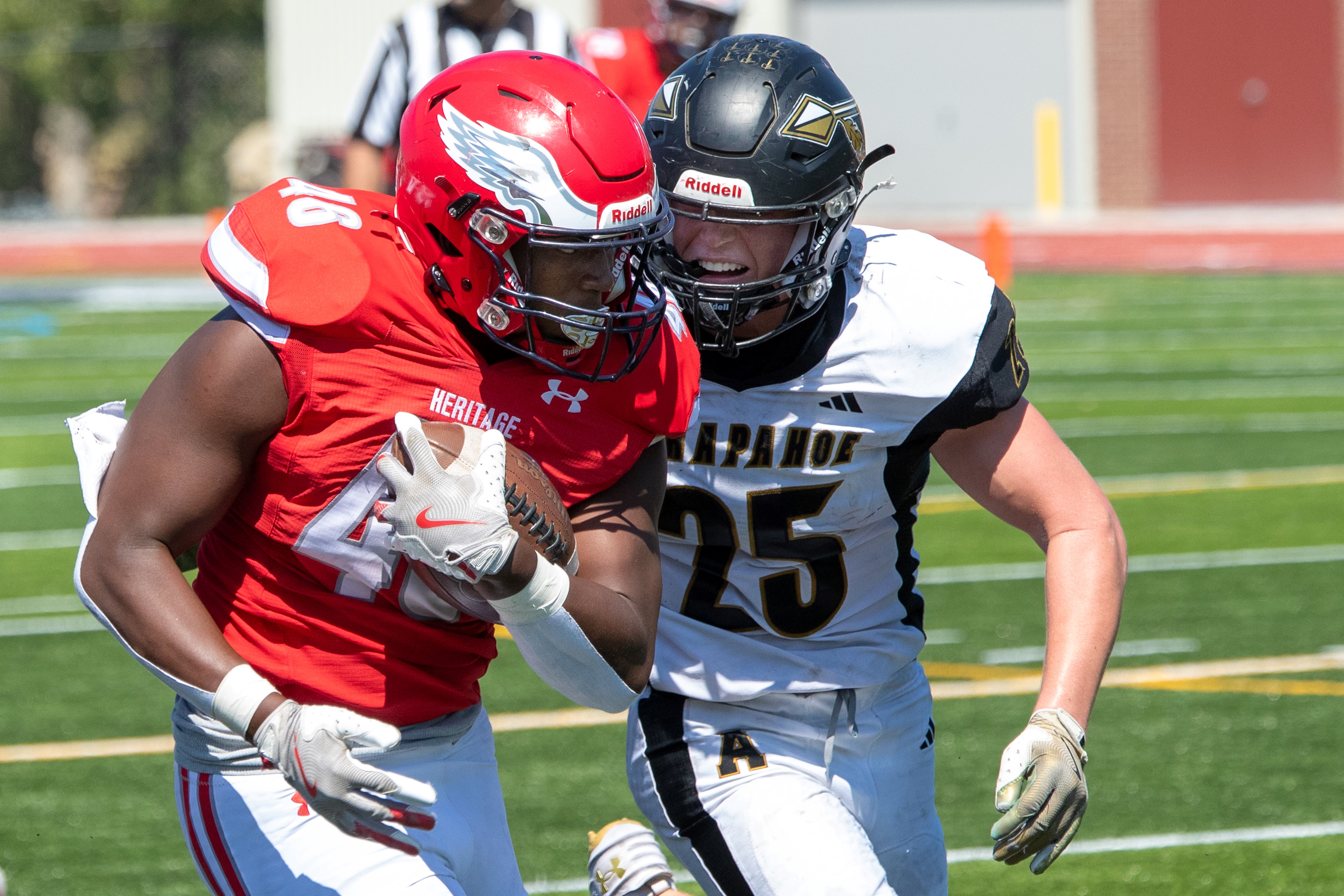 football player running with ball while opposing team attempts to tackle him
