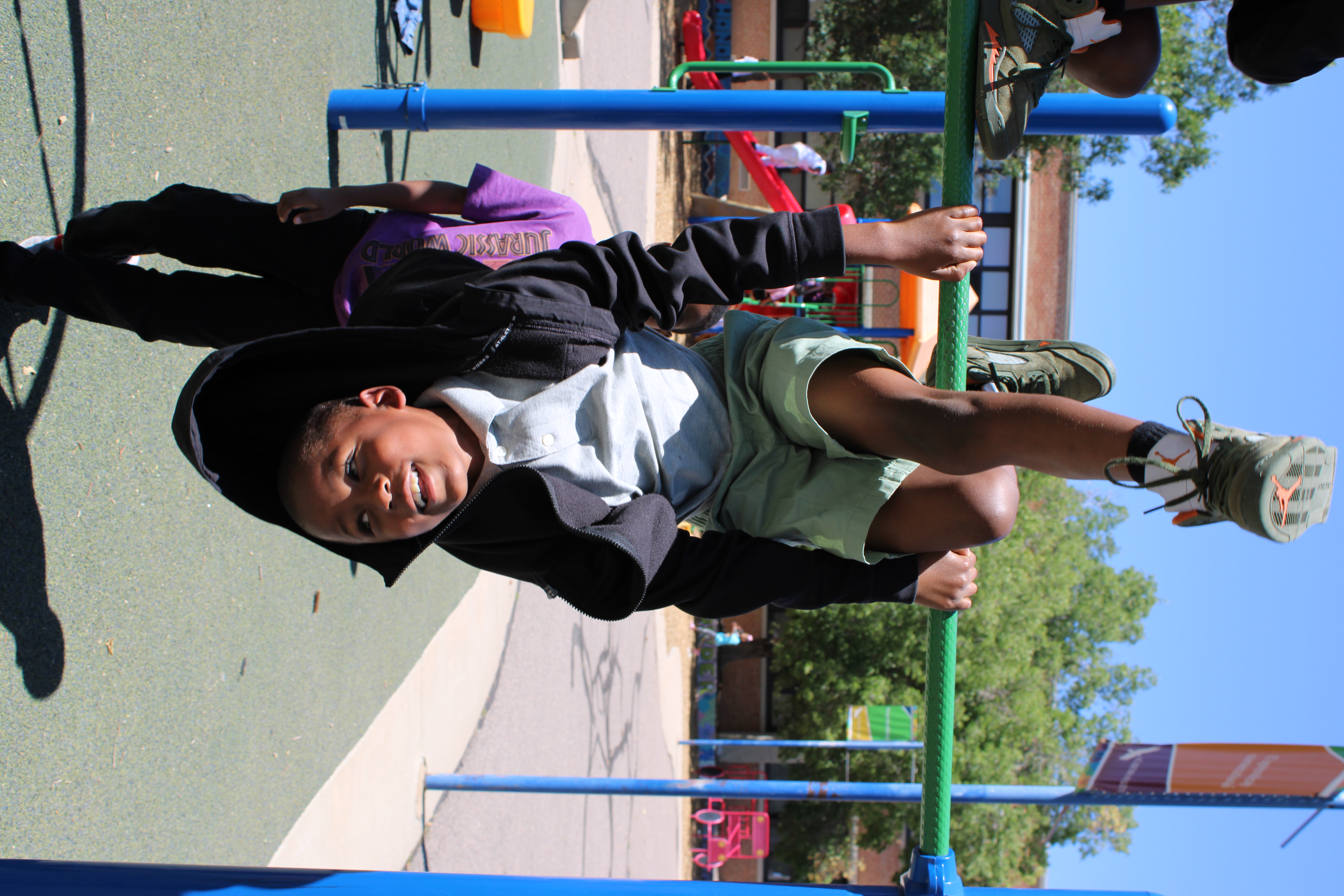 Student hanging upside down on playground